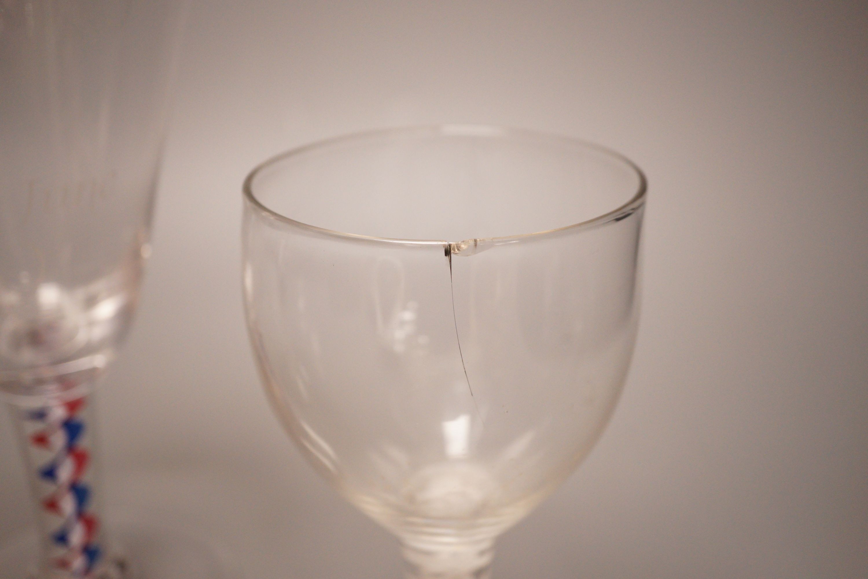 A mid 18th century drawn trumpet ale glass with air tear, a George III d.s.o.t. wine glass (a.f.) and a Whitefriars 1953 coronation colour twist wine glass